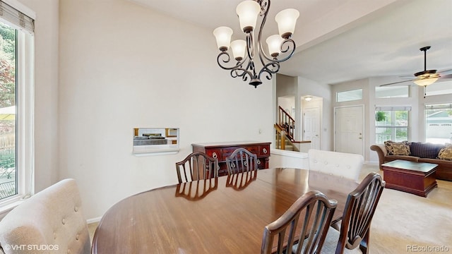 carpeted dining area featuring stairs, a chandelier, a ceiling fan, and baseboards