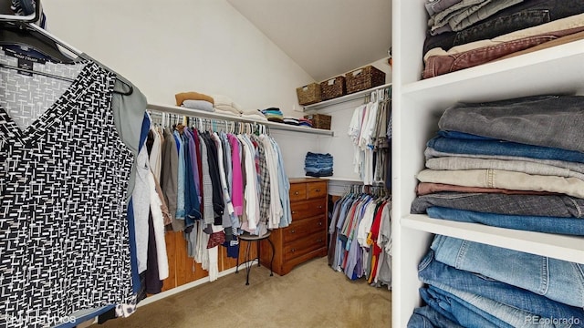 walk in closet with carpet floors and vaulted ceiling