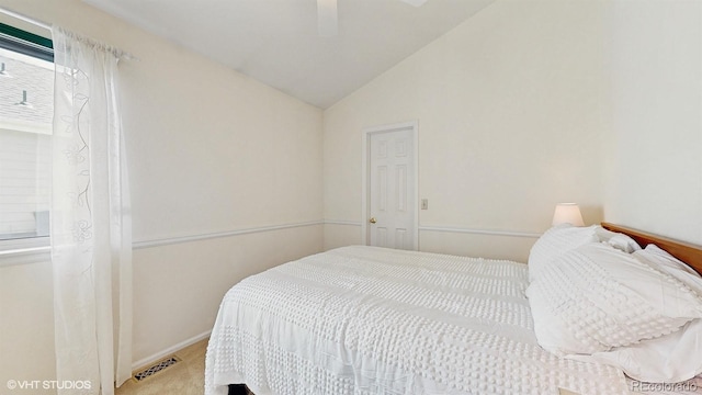 carpeted bedroom with vaulted ceiling and baseboards