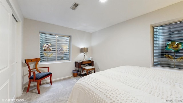 bedroom featuring light carpet, baseboards, and a closet