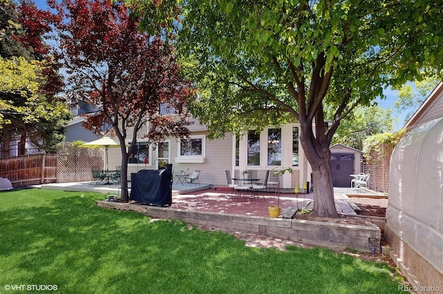 rear view of property with a patio area, a storage unit, and an outbuilding