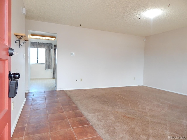 empty room with a textured ceiling and carpet