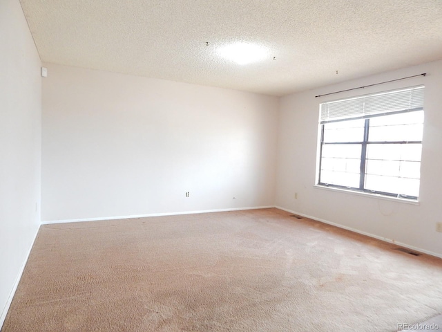 unfurnished room with a textured ceiling and light carpet