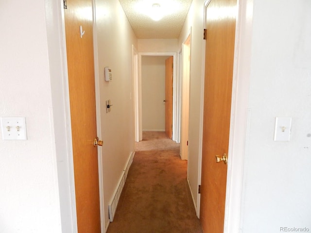 hallway featuring a textured ceiling and carpet flooring