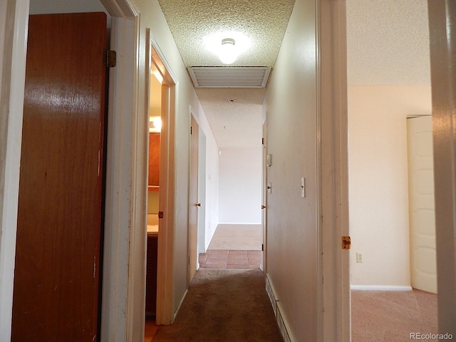 hall with light carpet and a textured ceiling