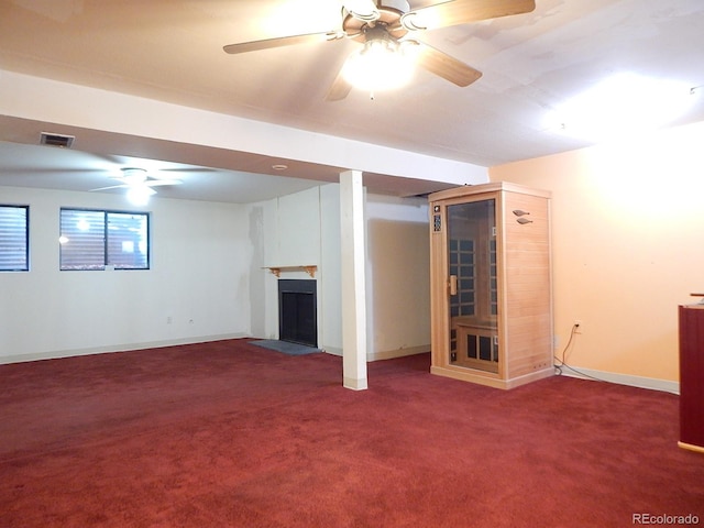 basement with ceiling fan and carpet