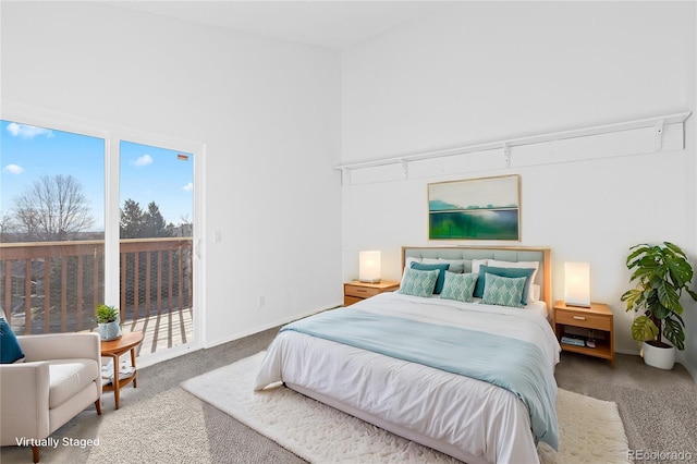 carpeted bedroom with access to outside, a high ceiling, and baseboards