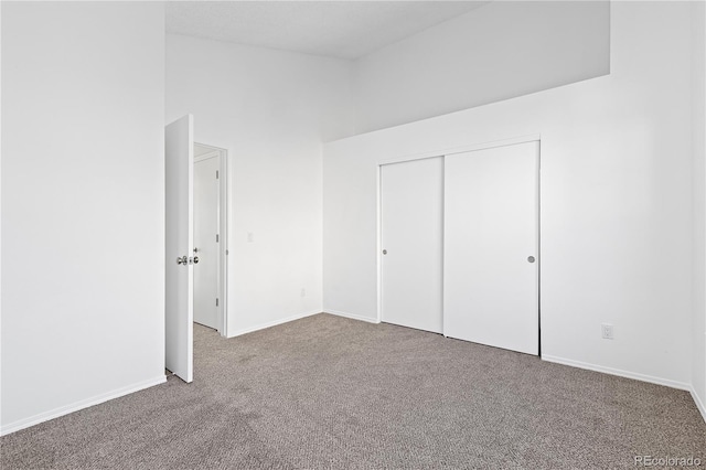 unfurnished bedroom featuring a closet, baseboards, and carpet flooring