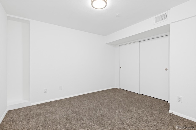 unfurnished bedroom featuring baseboards, a closet, visible vents, and carpet flooring