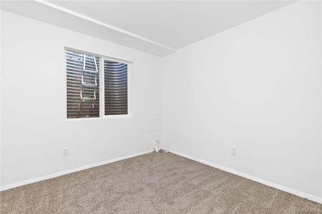 empty room featuring carpet floors and baseboards