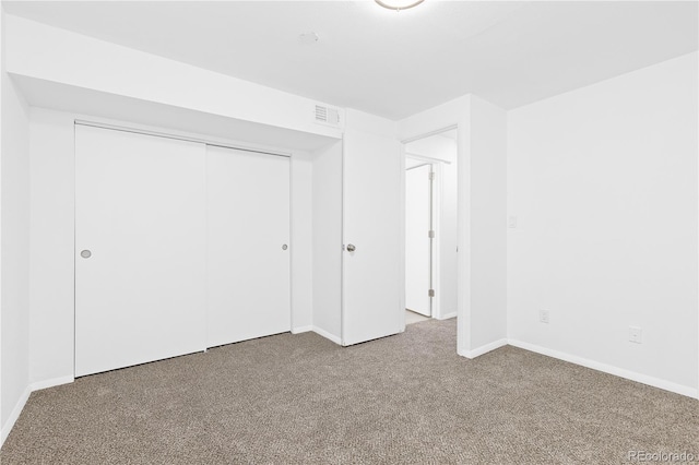 unfurnished bedroom featuring a closet, carpet, visible vents, and baseboards