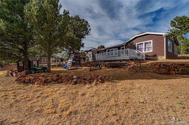 view of yard featuring a playground and a wooden deck