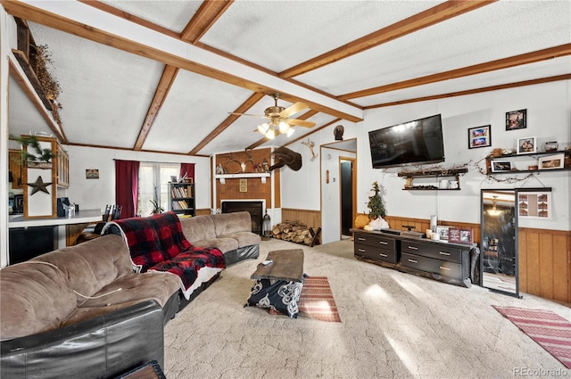 carpeted living room featuring lofted ceiling with beams, wood walls, a textured ceiling, and a fireplace