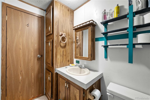 bathroom featuring vanity, a textured ceiling, and toilet