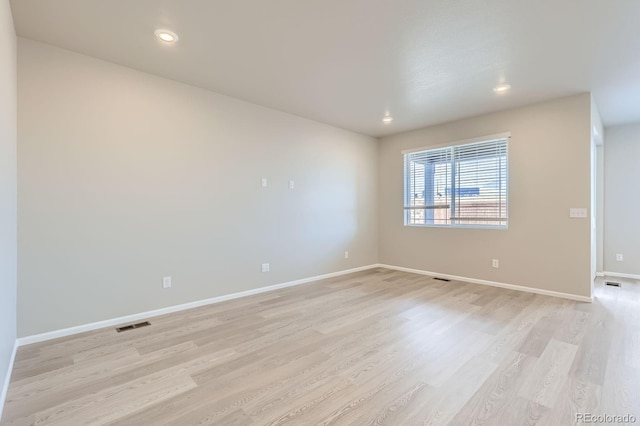 unfurnished room with visible vents, recessed lighting, baseboards, and light wood-type flooring