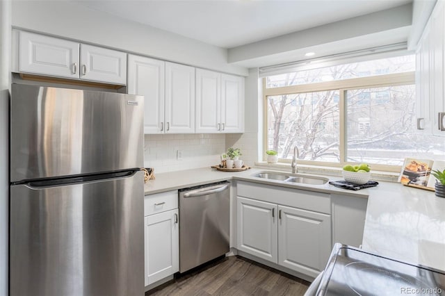 kitchen featuring tasteful backsplash, dark wood-type flooring, stainless steel appliances, white cabinets, and sink