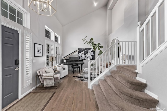 entryway featuring hardwood / wood-style flooring, high vaulted ceiling, and a notable chandelier