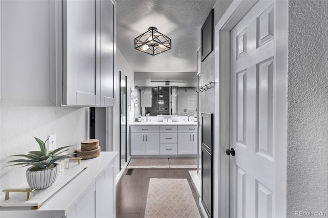 bathroom featuring a textured ceiling, vanity, and hardwood / wood-style flooring