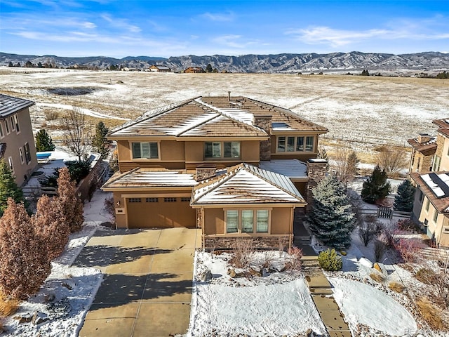 view of front of house with a garage, driveway, a mountain view, and stucco siding