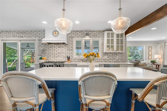 21 Fairway Ln, Littleton, CO 80123 - kitchen featuring light countertops, custom exhaust hood, white cabinets, a breakfast bar, and recessed lighting