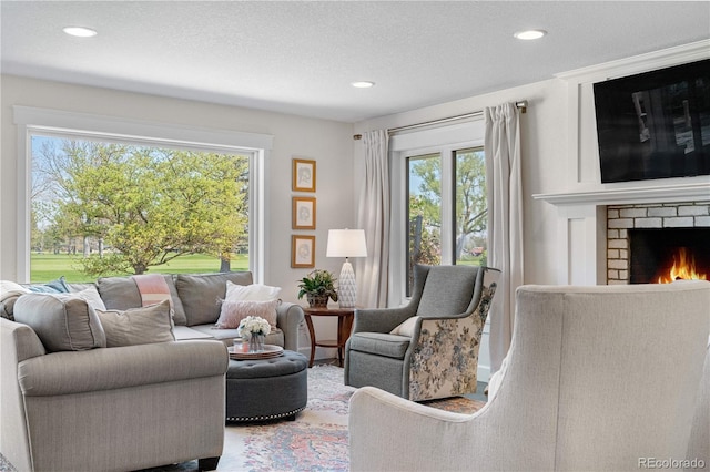 21 Fairway Ln, Littleton, CO 80123 - living room with plenty of natural light, recessed lighting, a brick fireplace, and a textured ceiling