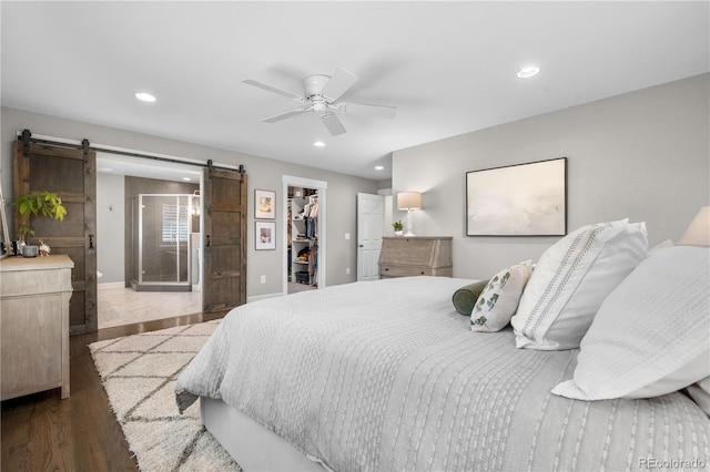 21 Fairway Ln, Littleton, CO 80123 - bedroom with a barn door, a spacious closet, recessed lighting, a closet, and ceiling fan