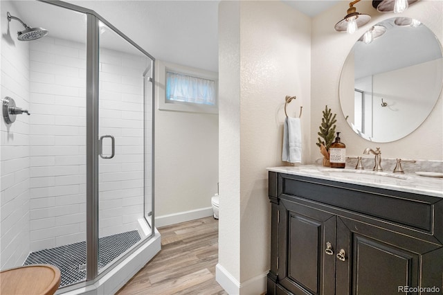 21 Fairway Ln, Littleton, CO 80123 - bathroom with wood finished floors, toilet, a shower stall, vanity, and baseboards