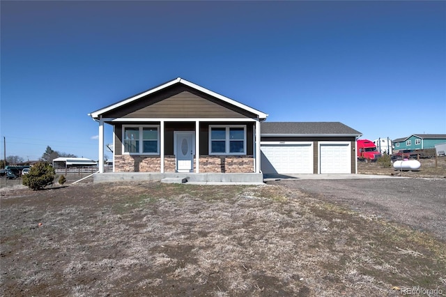 view of front of home with driveway, stone siding, and an attached garage