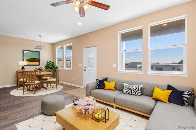 living room with recessed lighting, baseboards, wood finished floors, and ceiling fan with notable chandelier