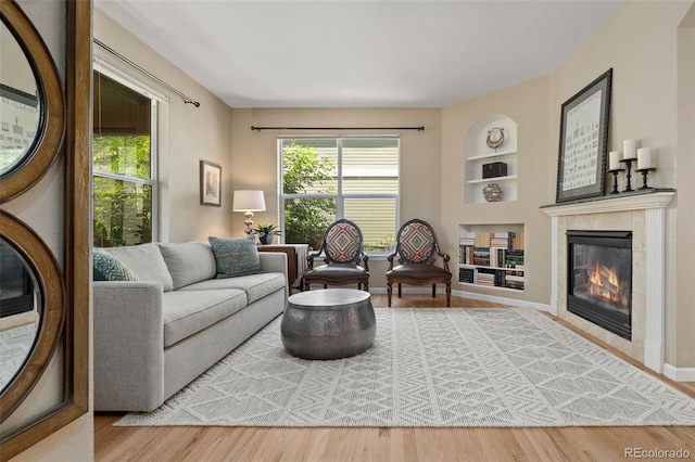 3670 Wolff St, Denver, CO 80212 - living room featuring built in features, healthy amount of natural light, a tiled fireplace, and wood finished floors