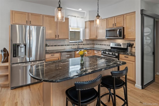 3670 Wolff St, Denver, CO 80212 - kitchen with stainless steel appliances, a kitchen bar, decorative backsplash, light wood-type flooring, and pendant lighting