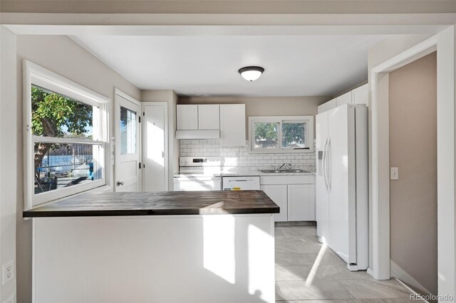 kitchen featuring tasteful backsplash, white cabinets, white appliances, butcher block counters, and sink