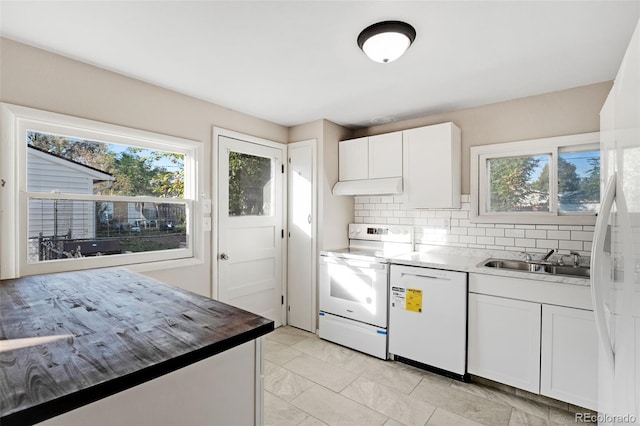 kitchen with a wealth of natural light, sink, white appliances, and white cabinetry