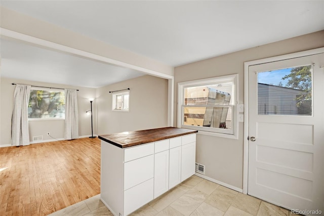 kitchen featuring light hardwood / wood-style floors, butcher block counters, and a wealth of natural light