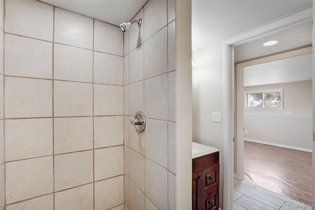 bathroom featuring tiled shower, vanity, and hardwood / wood-style flooring