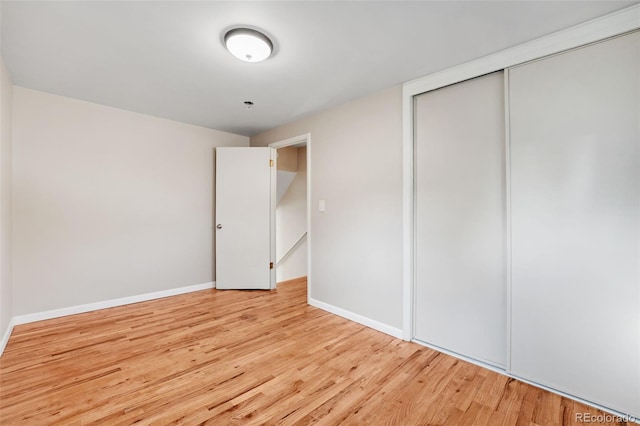 unfurnished bedroom featuring light hardwood / wood-style flooring and a closet