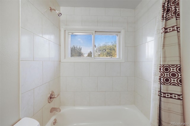 bathroom featuring toilet and shower / tub combo with curtain