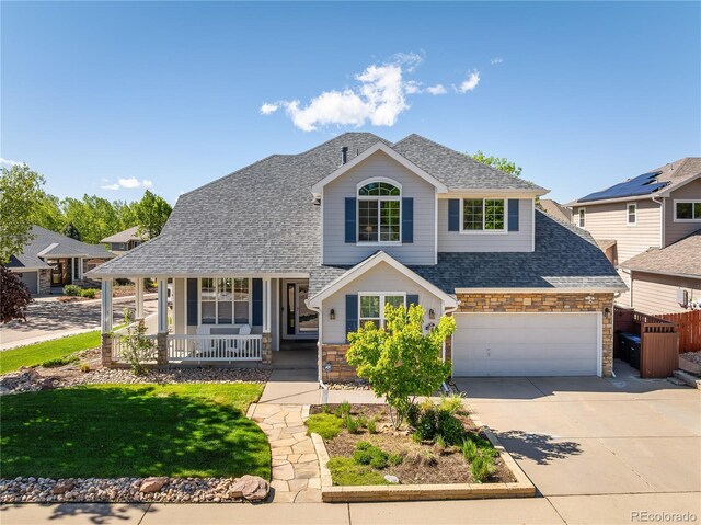 1996 Clipper Dr, Lafayette, CO 80026 - view of front facade with stone siding, covered porch, concrete driveway, roof with shingles, and an attached garage