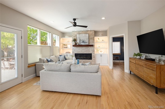 1996 Clipper Dr, Lafayette, CO 80026 - living area featuring light wood-type flooring, a stone fireplace, ceiling fan, baseboards, and recessed lighting