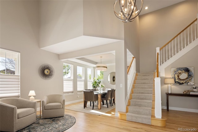 1996 Clipper Dr, Lafayette, CO 80026 - living room with stairs, wood finished floors, a towering ceiling, baseboards, and a chandelier