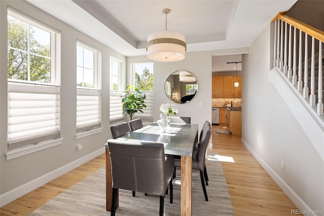 1996 Clipper Dr, Lafayette, CO 80026 - dining space with light wood-style floors, healthy amount of natural light, a tray ceiling, and baseboards