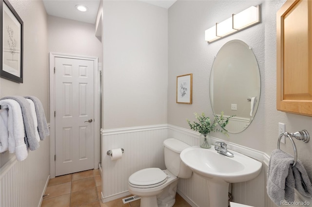 1996 Clipper Dr, Lafayette, CO 80026 - bathroom featuring toilet, tile patterned floors, a wainscoted wall, and a sink