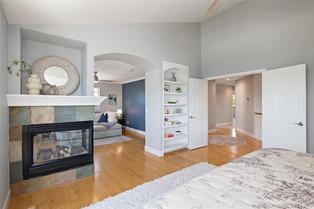 1996 Clipper Dr, Lafayette, CO 80026 - bedroom with baseboards, a tile fireplace, wood finished floors, high vaulted ceiling, and arched walkways