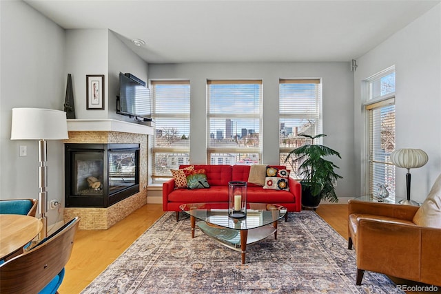 living room featuring a tile fireplace and wood finished floors