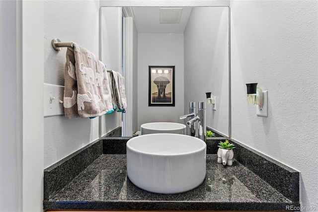 bathroom with vanity and a textured wall