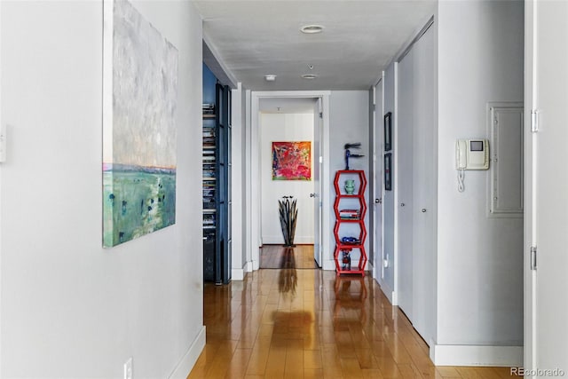 corridor with baseboards and light wood-style floors