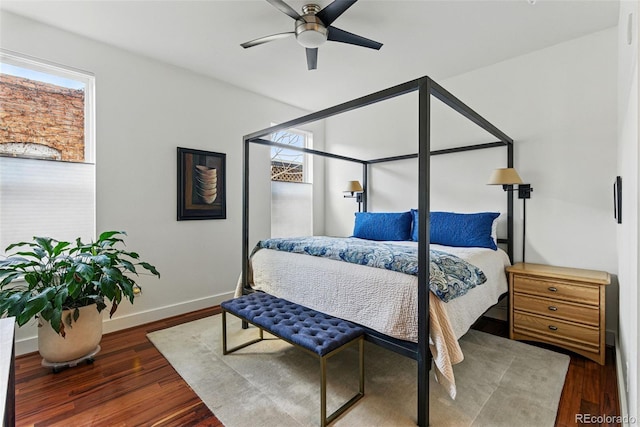 bedroom with a ceiling fan, wood finished floors, and baseboards