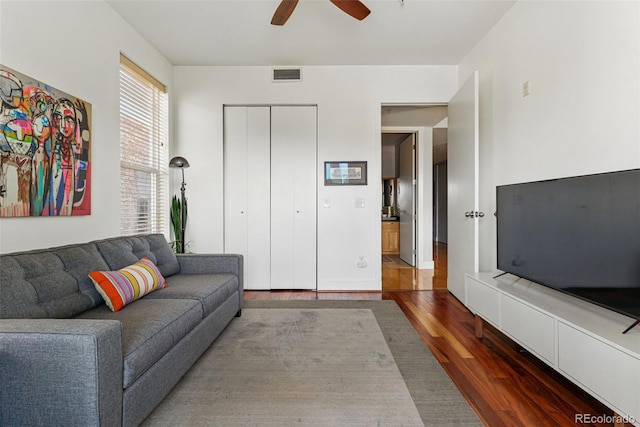 living area featuring a ceiling fan, wood finished floors, and visible vents