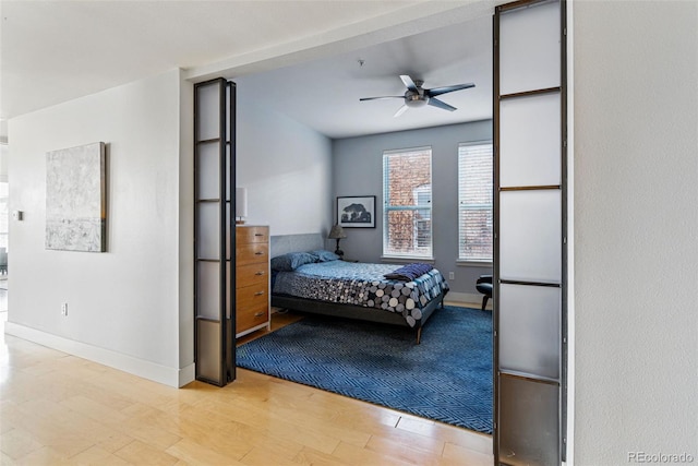 bedroom featuring ceiling fan, baseboards, and wood finished floors