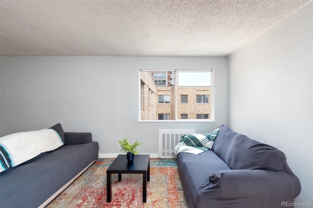 living room featuring radiator heating unit and a textured ceiling